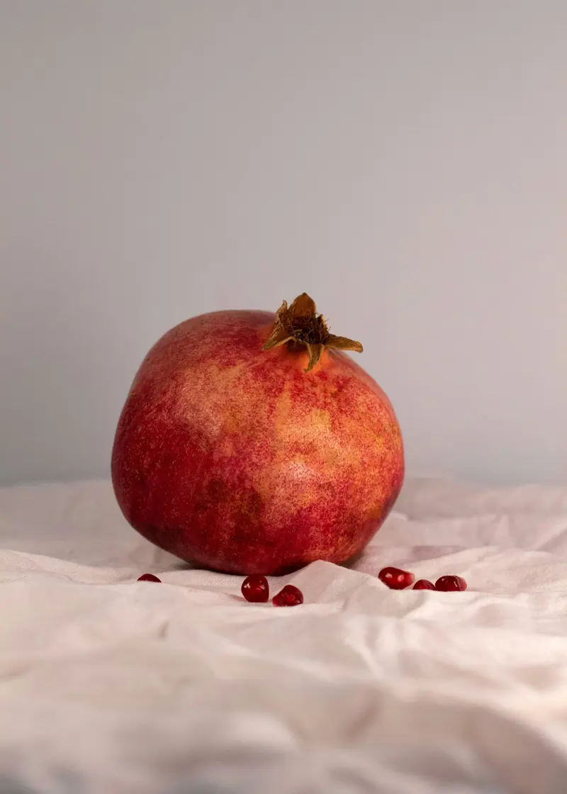 A whole pomegranate on white linen