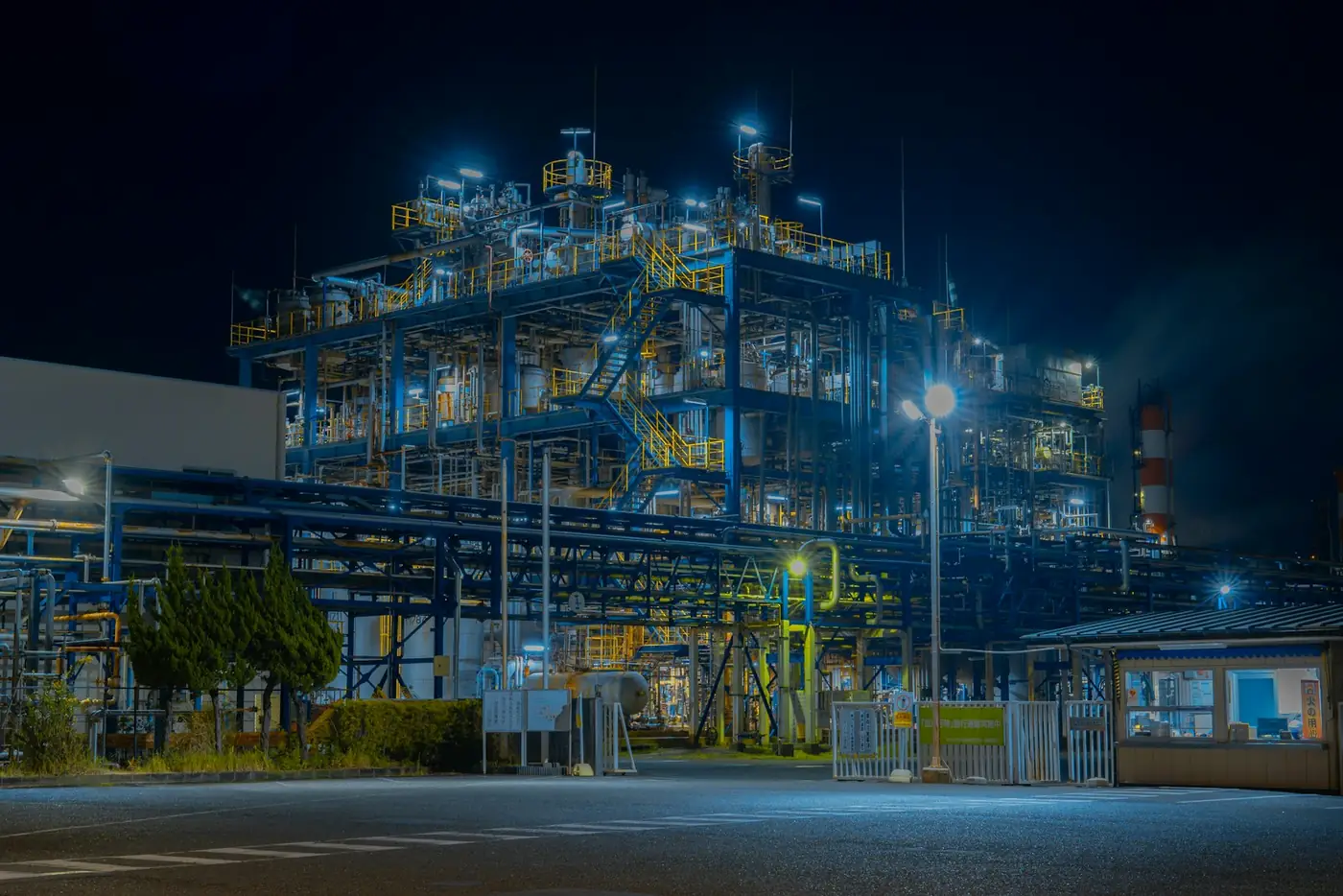 Wide view of a large process plant with its lights on at night