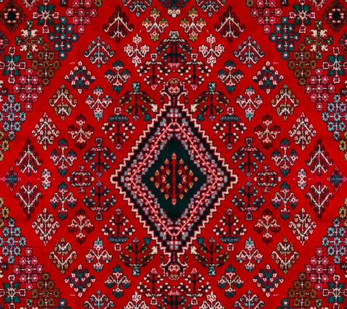 Kırmızı zeminli, geometrik desenli makine halısı