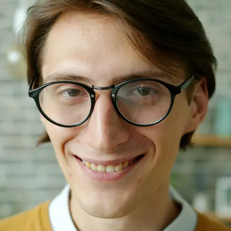 Porträt eines lächelnden jungen Mannes mit Brille