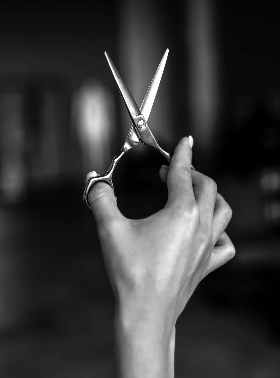 Geöffnete Haarschere zwischen den Fingern