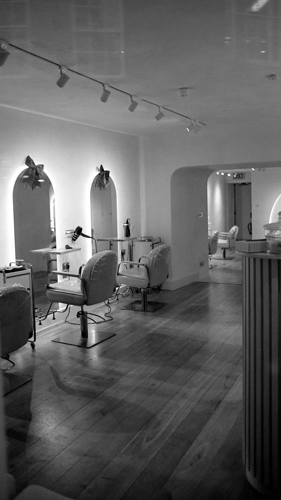 Heller Salon mit gewölbten Spiegeln und Friseurstühlen