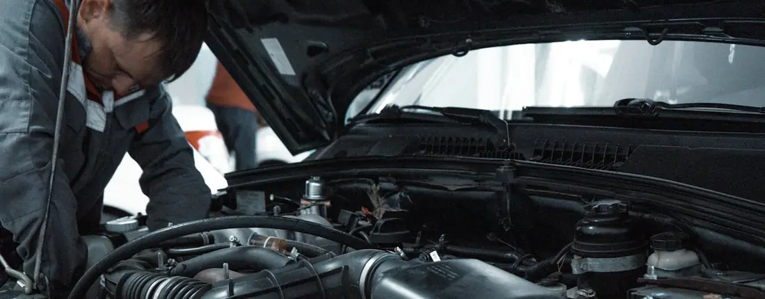 Mechaniker prüft den Motor unter der geöffneten Haube