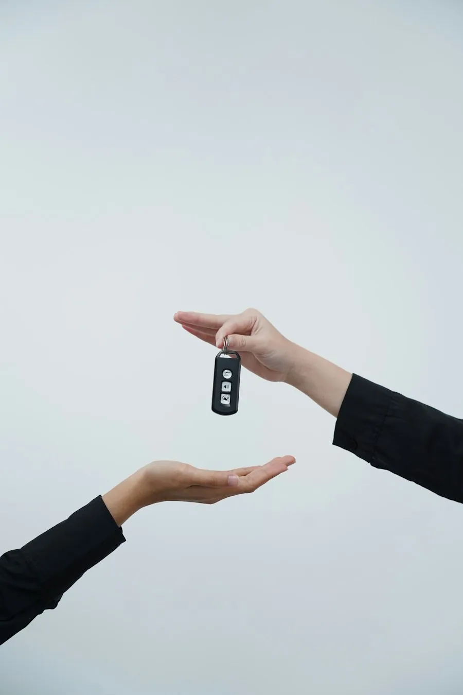 Eine Hand legt einen Autoschlüssel in eine geöffnete Hand