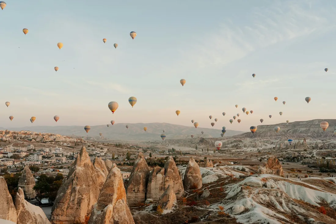 Balloons at sunrise above the fairy chimneys near Göreme