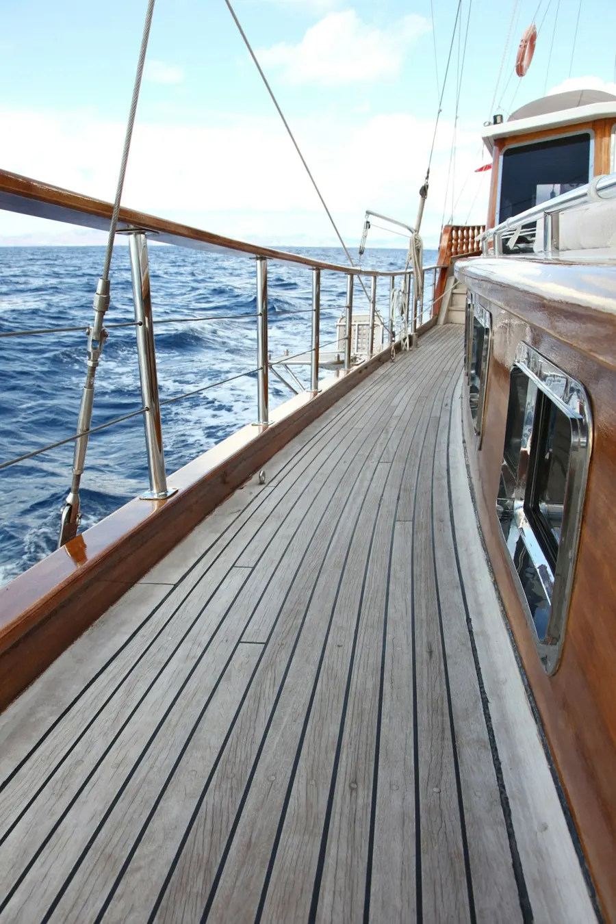 Teakdeck einer Gulet, die Reling führt aufs offene Meer